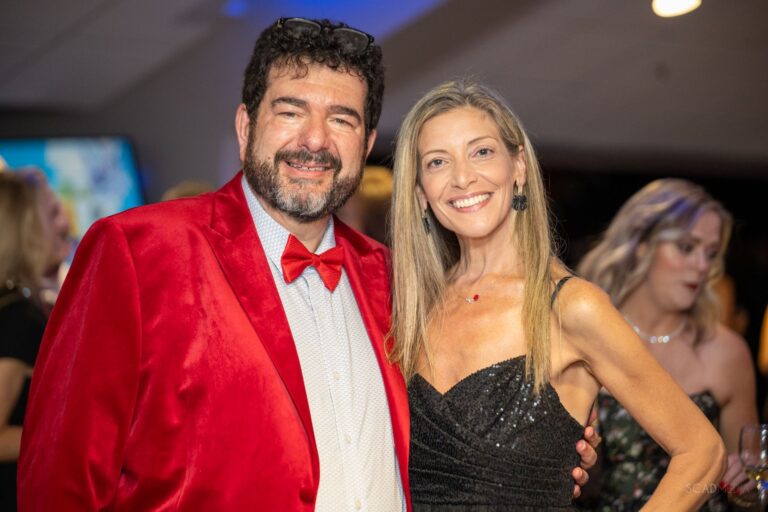 Couple posing, one in a red velvet jacket